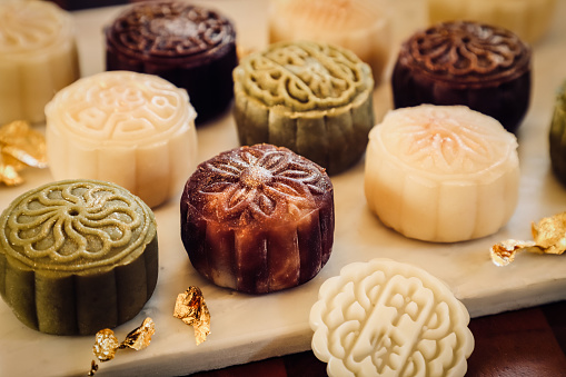 Snowskin Mooncake, the non-traditional mooncake that doesn't require any baking. Sweet bean paste or custard wrapped in mochi dough of various flavours, then moulded in mooncake mould. The mooncakes are then placed on a rectangular marble slab after moulding. The Chinese characters on the matcha mooncake and stamp mean mid-autumn.