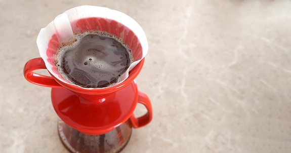 Pourover. v60. Delicious aromatic coffee filter is brewed in a red ceramic dropper. Close-up, view from above