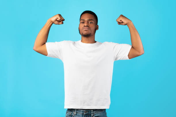 istock Strong Black Guy Showing Biceps Posing On Blue Background 1271711561