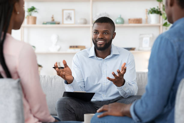 family psychotherapy. friendly black therapist consulting african american couple at his office - mental health professional family couple psychiatrist imagens e fotografias de stock