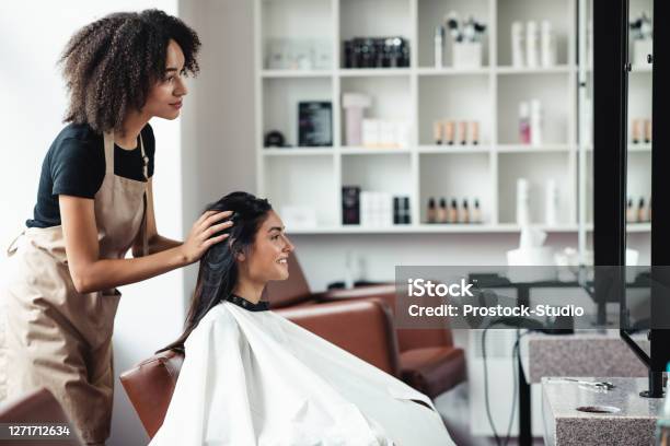 Young Woman Looking For Changes Trying New Hairstyle At Beauty Salon Stock Photo - Download Image Now