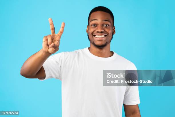 African Man Showing Number Two Posing On Blue Studio Background Stock Photo - Download Image Now
