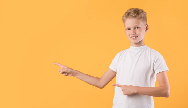 istock Smiling boy pointing finger aside at copy space 1271713444