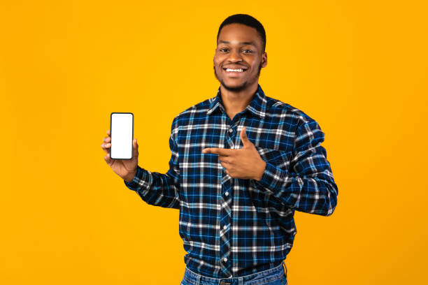 istock Cheerful African Man Showing Smartphone Blank Screen, Yellow Background, Mockup 1271713579