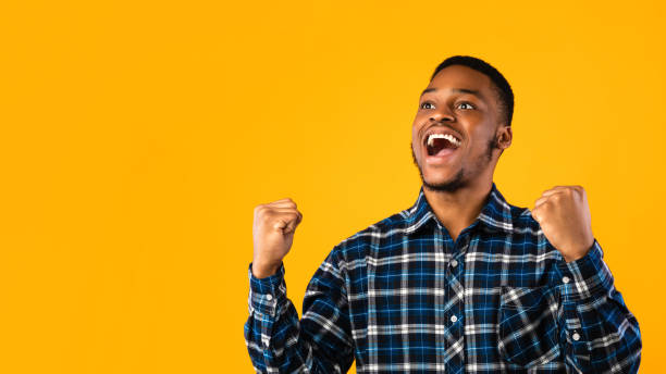 istock Excited Black Man Shouting Shaking Fists On Yellow Background, Panorama 1271713587