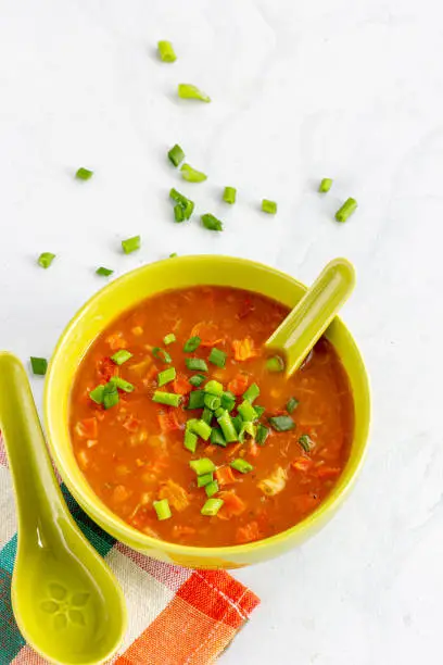 Simple Vegetable Soup in a Bowl with Spoon Top Down Vertical Photo