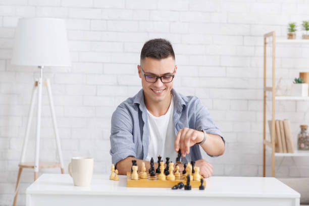 istock Self-isolation, online education concept. Cheerful guy plays in chess online with virtual partner 1271714838