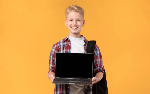 istock School boy showing laptop screen at camera 1271714862