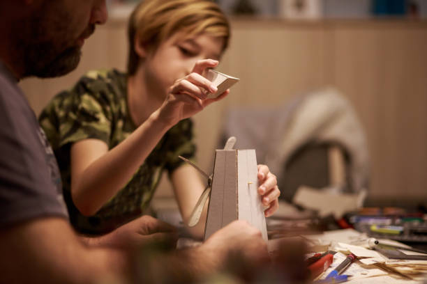 Teenage boy and his father doing a homeschooling craft during quarantine