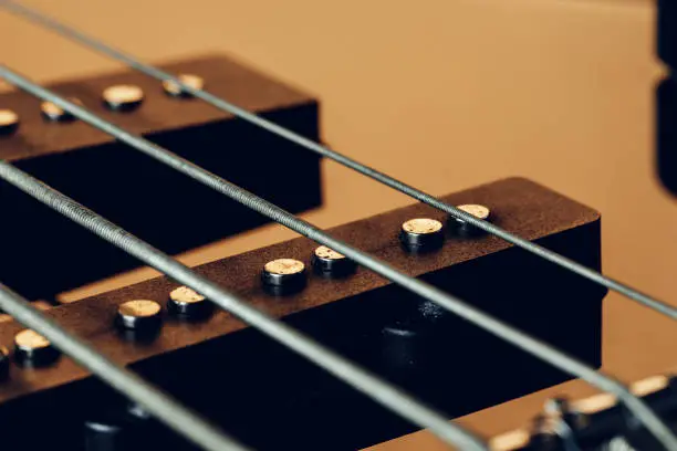 Close up photo of electric guitar fingerboard on dark background