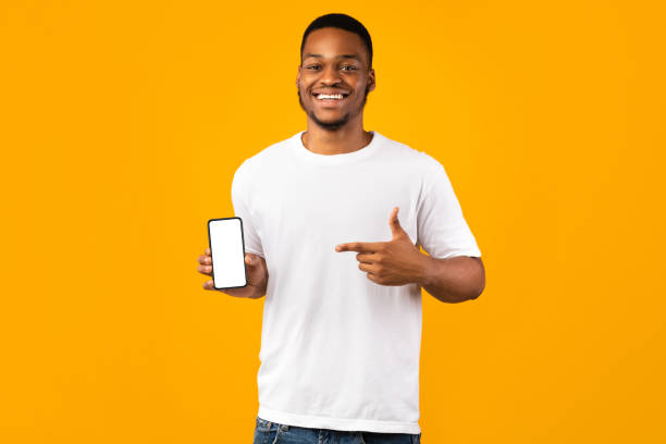 istock Positive Black Guy Showing Phone Empty Screen On Yellow Background 1271721013