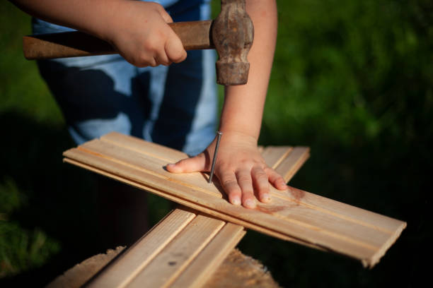 istock Child girl hammers a nail into the board. 1271723848