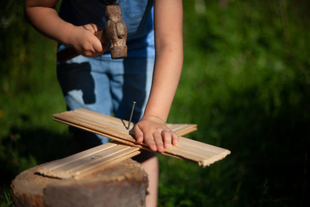 istock Child girl hammers a nail into the board. 1271723880