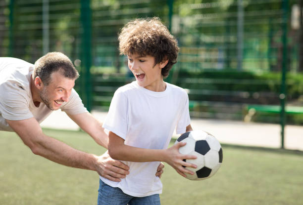 istock Joyful dad teaching his son how to play soccer 1271724035