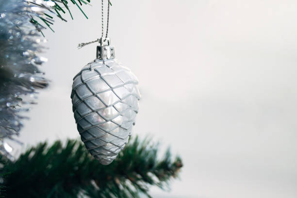 istock Silver white toy cone hanging on artificial Christmas tree with copy space. Selective focus. Holiday card with decorations for the New Year's Eve 1271724120