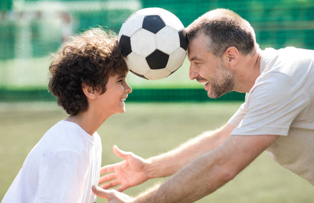 istock Man holding ball between two heads with little boy 1271726300