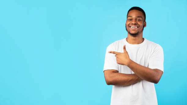 istock African Guy Pointing Finger Aside At Copyspace, Blue Background, Panorama 1271726597