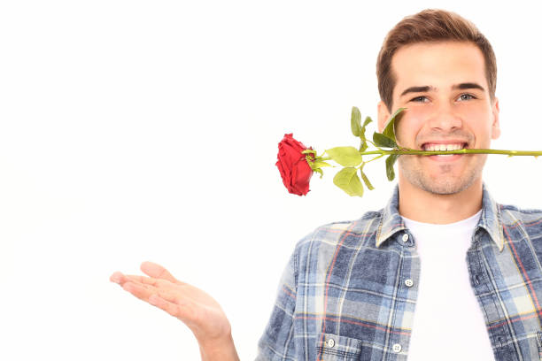 istock Romantic young man smelling red rose isolated on white. Mock up and copy space. Valentines day 1271726844