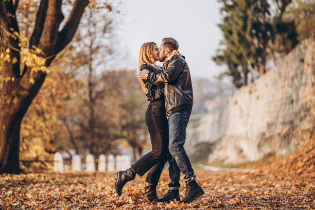Full length portrait of a happy loving couple walking outdoor in the autumn park. stock photo
