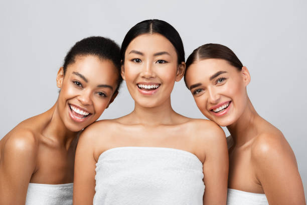 istock Three Young Women Laughing Posing Wrapped In Towels, Gray Background 1271730903