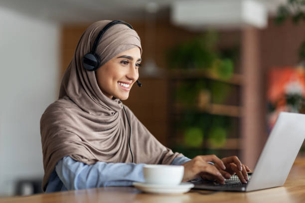 garota muçulmana sorridente estudando online no café - traditional clothing audio - fotografias e filmes do acervo