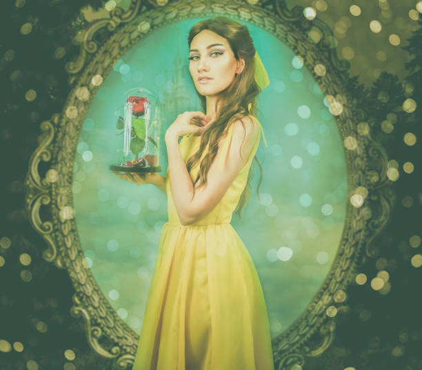 Woman in the yellow dress with red rose in her hands on the background of the mirror and the castle. Beauty and the beast cosplay art processing Woman in the yellow dress with red rose in her hands on the background of the mirror and the castle. Beauty and the beast cosplay art processing. beauty and beast rose stock pictures, royalty-free photos & images