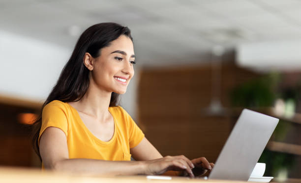 istock Smiling pretty girl using laptop at cafe 1271731863