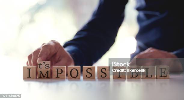 Businessman Changing The Word Impossible To Possible By Flipping Over Wooden Cube Stock Photo - Download Image Now
