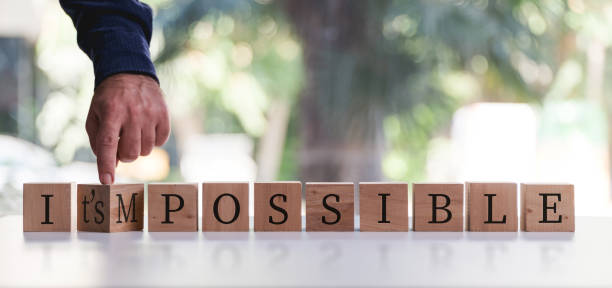 istock Businessman Changing The Word Impossible To Possible By Flipping Over Wooden Cube. 1271736211