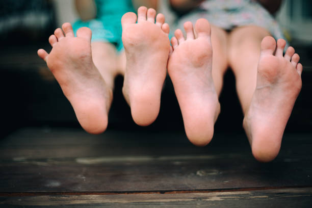 Running children's legs. Children's legs running along the path close-up. Red garden path. The concept of childhood. Barefoot childhood. Garden path after the rain.