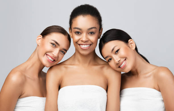 istock Three Multiracial Women Wrapped In Towels Posing On Gray Background 1271738297