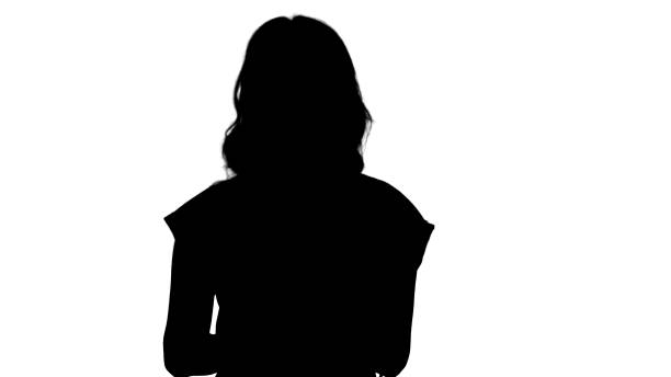 istock Silhouette Lady wearing red t-shirt holding a tablet in her hands with a serious face talking to camera 1271739314