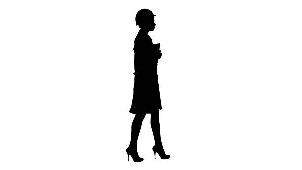 istock Silhouette Attractive Hispanic woman in white lab coat and white safety hard hat walking holding notebook or tablet 1271739522