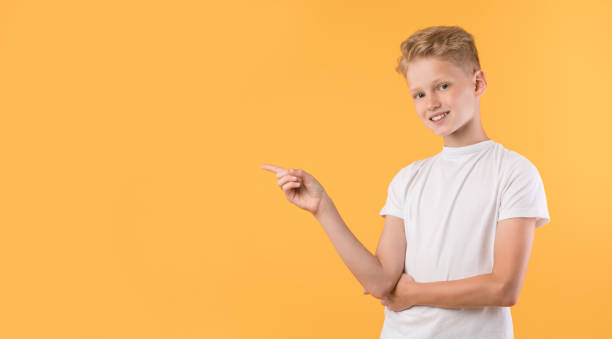 istock Happy boy pointing finger aside at copy space 1271739623