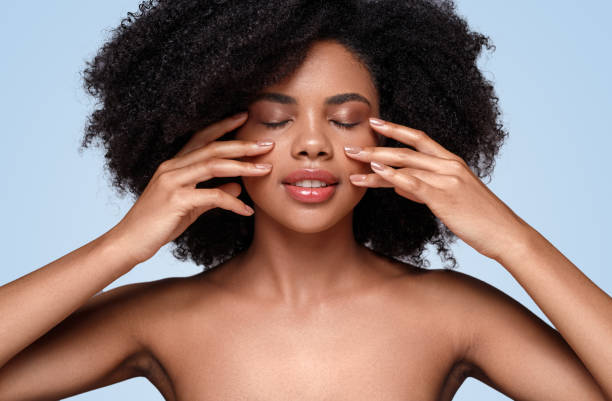 istock African American woman applying cream on cheeks 1271739685