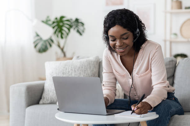 istock Online Education. African Girl Using Laptop And Headset For Study At Home 1271739816