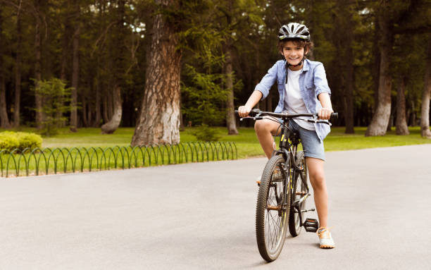 istock Boy standing on a bicycle in public park 1271739882