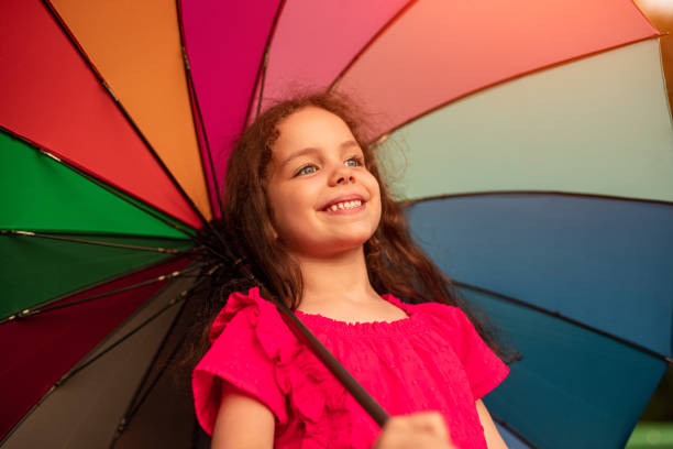 istock Happy child with colorful umbrella 1271739991
