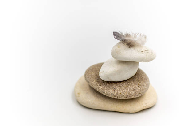 istock Pile of rocks with a feather or a red flower 1271741718