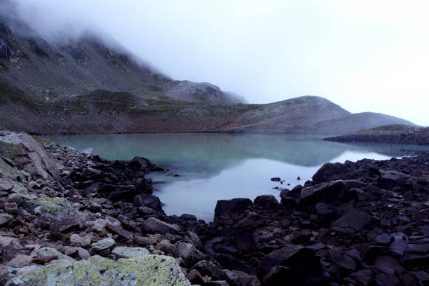 istock Alpine lake in the clouds. 1271741727