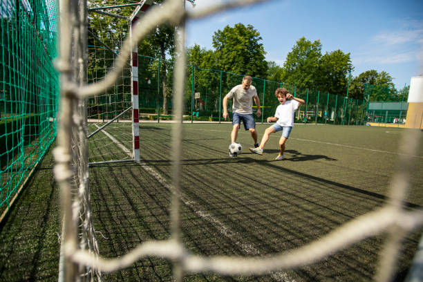istock Sportive dad playing football with his son 1271742083