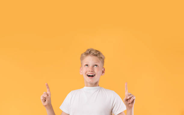 istock Smiling boy pointing finger up at copy space 1271742116