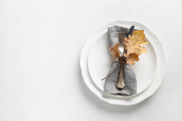 istock Fall table setting with autumn leaves and white plate on white table. Top view. Copy space. 1271742806