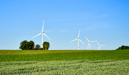 Countryside landscape with windmills or wind turbines generating electricity power