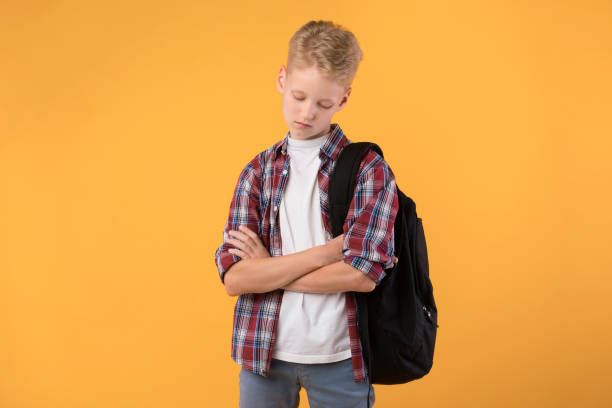 istock Sad little boy with folded arms alone at studio 1271743442