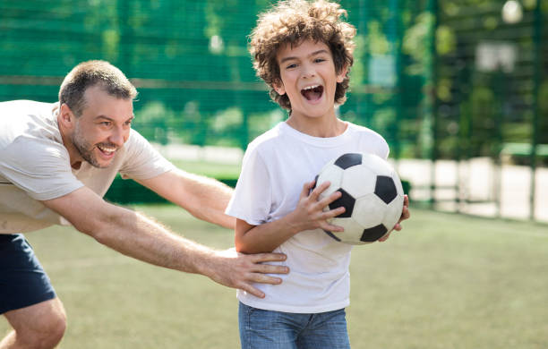 istock Sportive dad teaching his son how to play soccer 1271744399