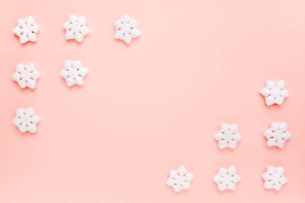 istock Christmas frame with white christmas snowflakes on pink background. Christmas composition, wallpaper. Flat lay, top view 1271747218
