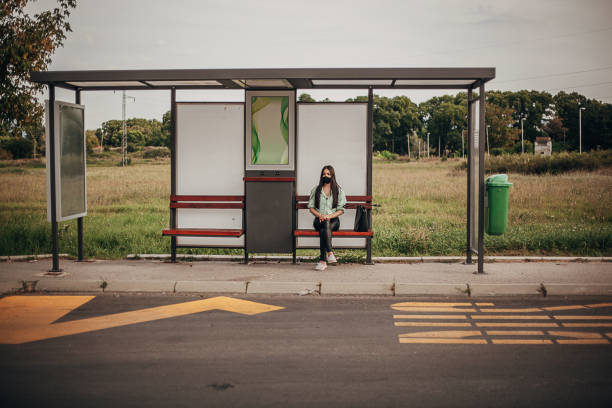 istock Young woman with protective face mask waiting for a bus 1271748925