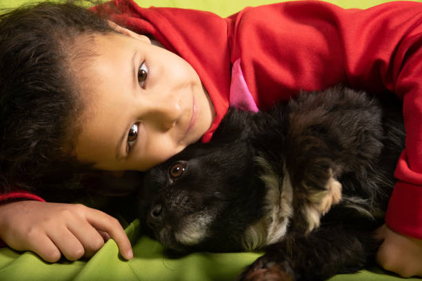 Child playing with puppy, small depth of field and selective focus.