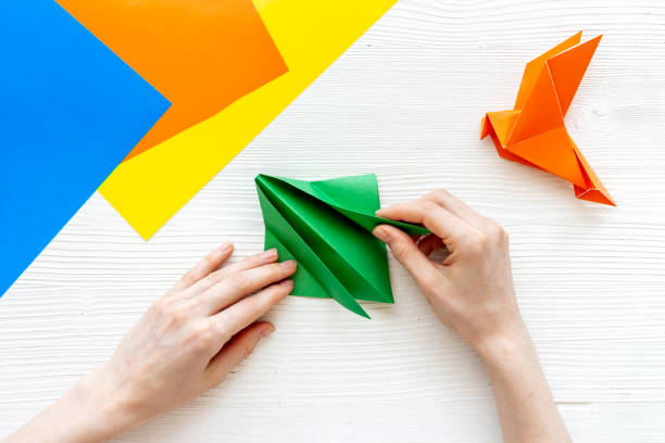 istock DIY concept. Doing origami paper bird, Top view 1271754495
